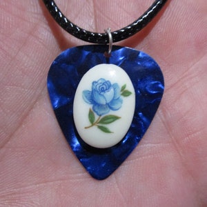 May include: A blue guitar pick necklace with a white porcelain pendant featuring a blue rose.