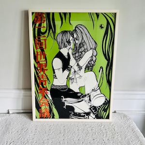 May include: Framed art print featuring a black and white illustration of two figures embracing on a scooter, set against a vibrant green background. The artwork includes Japanese text in red and black, and is framed in a white border.