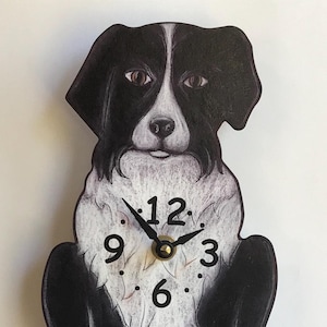 May include: A black and white border collie dog clock with a pendulum tail. The clock face is on the dog's belly and has black numbers and hands.