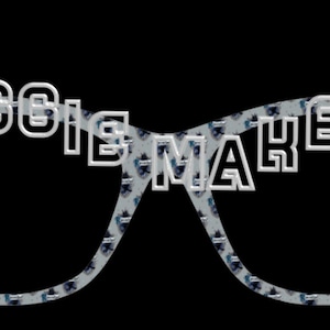 May include: A graphic of eyeglasses with the words "GROGGIE MAKES IT" in white, outlined letters. The lenses are filled with a pattern of small, dark blue and white shapes against a light blue background. The background is black.