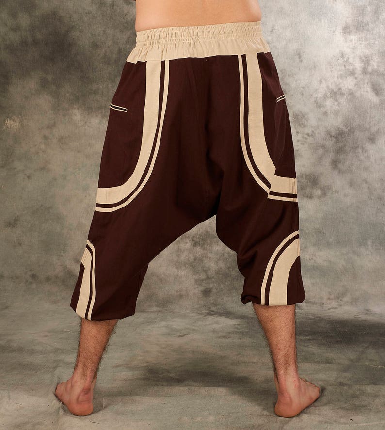 Puede incluir: Pantal&oacute;n marr&oacute;n con un dise&ntilde;o geom&eacute;trico blanco. El pantal&oacute;n tiene una pierna ancha y un ajuste holgado.