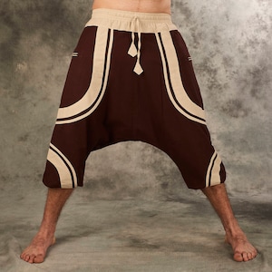 Puede incluir: Pantalones de color marr&oacute;n y beige con estampado, de corte holgado y cintura con cord&oacute;n.