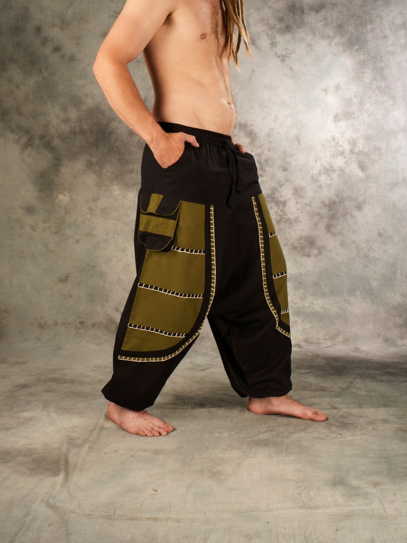May include: Black and green pants with decorative stitching. The pants have a wide leg and a drawstring waist.
