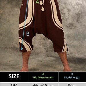 Puede incluir: Una tabla de tallas para pantalones marrones y blancos con estampado y cintura con cord&oacute;n. La tabla muestra las medidas de cadera en cent&iacute;metros y la longitud del pantal&oacute;n en cent&iacute;metros. Las tallas incluyen S/M y L/XL.