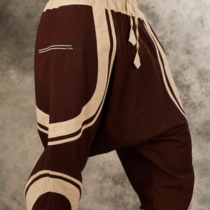Puede incluir: Pantalones de color marr&oacute;n y beige con un patr&oacute;n. Tienen una pierna ancha y est&aacute;n hechos de una tela suave y c&oacute;moda.