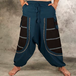 May include: Blue and black pants with decorative stitching. The pants have a wide leg and a drawstring waist.