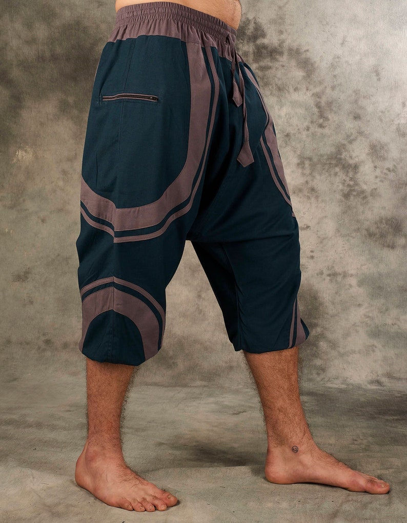 Puede incluir: Pantalones de color azul oscuro y gris con estampado y cintura con cord&oacute;n. Los pantalones son cortos y de corte holgado.