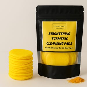 May include: A stack of bright yellow cleansing pads next to a black pouch with a yellow label. The label reads "Brightening Turmeric Cleansing Pads" and "Gentle Cleanser for All Skin Types". A small pile of turmeric powder is also visible.