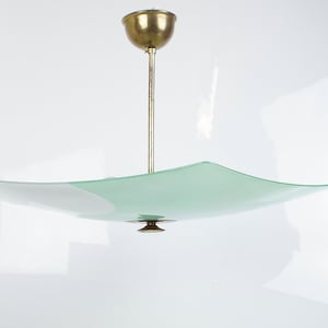 May include: A brass and glass ceiling light fixture with a square, curved, green and white glass shade.