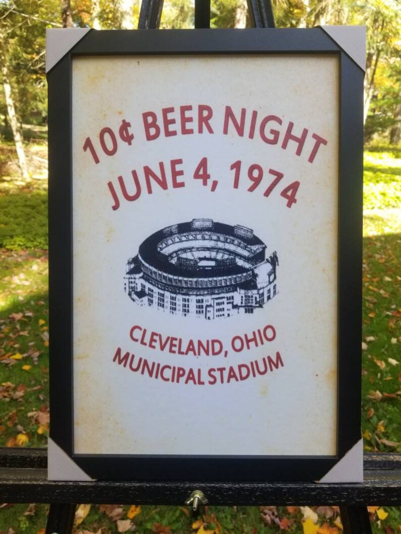 May include: A vintage-style poster advertising a 10&cent; beer night at Cleveland Municipal Stadium on June 4, 1974. The poster features a black and white illustration of the stadium.