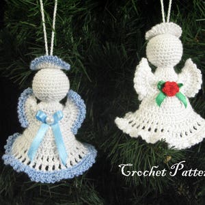 May include: Two crocheted angel ornaments hanging on a Christmas tree. One angel is white with a red flower and green leaves, the other is white with a blue ribbon and a white pearl.