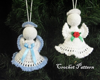 May include: Two crocheted angel ornaments hanging on a Christmas tree. One angel is white with a red flower and green leaves, the other is white with a blue ribbon and a white pearl.
