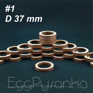 Puede incluir: Anillos de madera, cada uno de 37 mm de diámetro, apilados y dispuestos en forma de pirámide. Los anillos son de color marrón claro con un borde marrón más oscuro. El texto "#1 D 37 mm" está en la parte superior izquierda. La palabra "EggPysanka" está en la parte inferior.