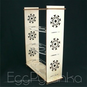 Puede incluir: Un soporte para huevos de madera con cuatro niveles y un dise&ntilde;o floral decorativo. Cada nivel tiene seis ranuras para guardar huevos. El soporte est&aacute; hecho de madera natural y tiene un acabado marr&oacute;n claro.