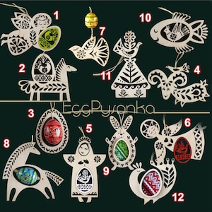 May include: Twelve wooden ornaments with intricate designs, each featuring a different Easter theme. The ornaments are painted in black and white with a variety of patterns and designs. The ornaments are numbered 1 through 12.