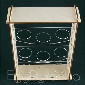 Puede incluir: Un soporte para huevos de madera con tres estantes, cada uno con capacidad para seis huevos. El soporte est&aacute; hecho de madera clara con un tinte marr&oacute;n y tiene un dise&ntilde;o decorativo en los lados. Los estantes est&aacute;n hechos de acr&iacute;lico transparente.