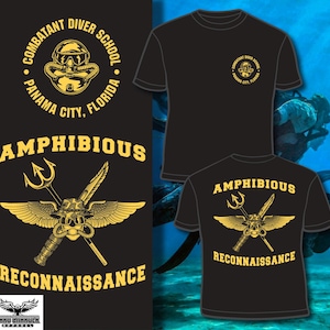 May include: Black t-shirts with gold graphics. One shirt features a circular design with text "COMBATANT DIVER SCHOOL PANAMA CITY, FLORIDA". Another shirt displays "AMPHIBIOUS RECONNAISSANCE" with a trident, wings, and a diver's mask.