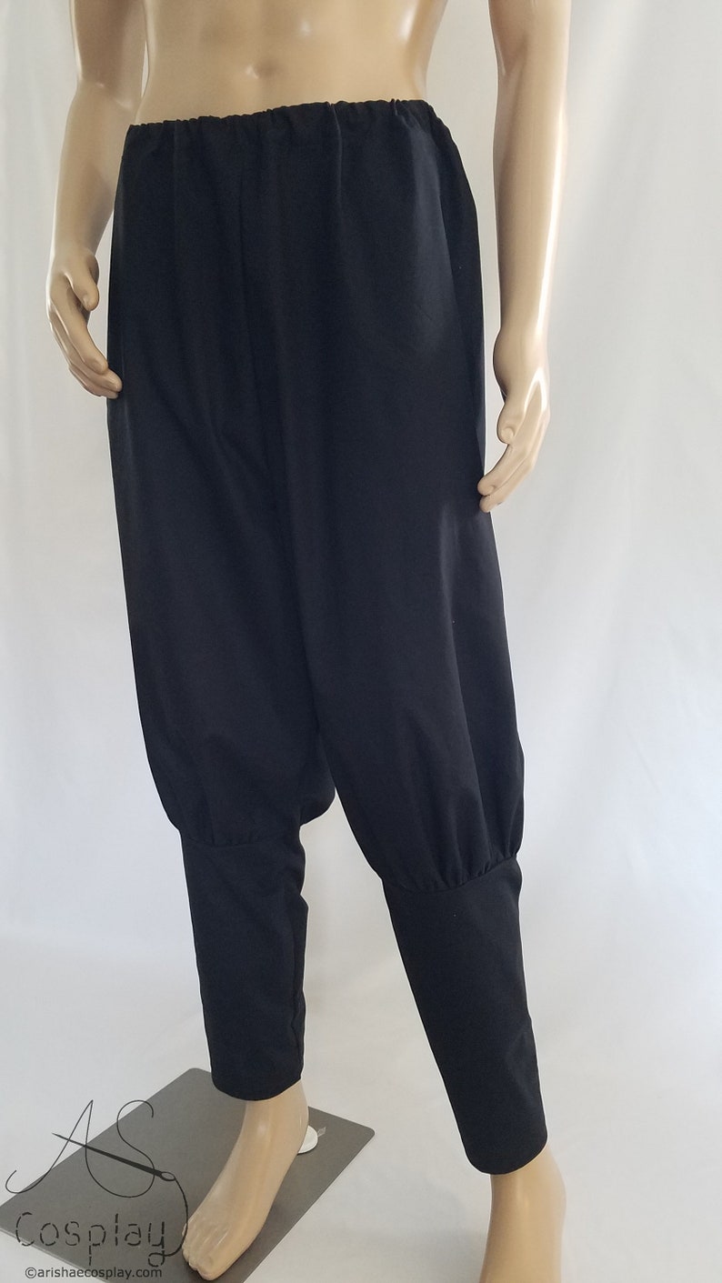 May include: Black pants with a gathered elastic waistband and cuffed legs. The pants are made of a soft, lightweight fabric.