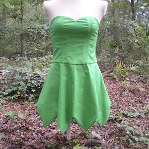 May include: A strapless green dress with a sweetheart neckline and a flared skirt. The skirt has a pointed hemline.