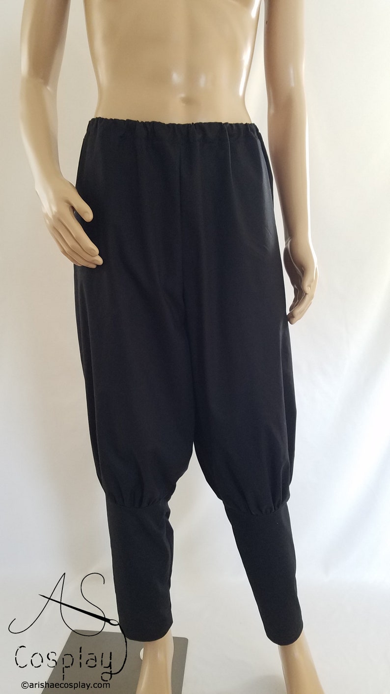 May include: Black pants with a gathered elastic waistband and cuffed legs. The pants are made of a soft, lightweight fabric.