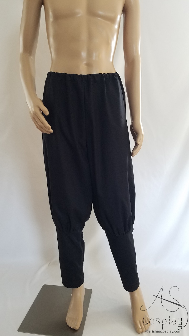 May include: Black pants with a gathered elastic waistband and cuffed legs.