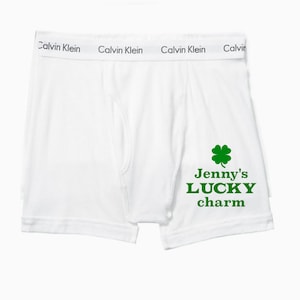 Puede incluir: Bóxer blanco con un trébol de cuatro hojas verde y el texto "Jenny's LUCKY charm" impreso en la parte delantera.
