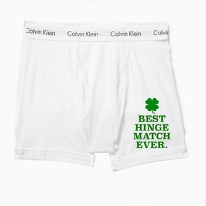 Puede incluir: Bóxer blanco Calvin Klein con un trébol de cuatro hojas verde y el texto "BEST HINGE MATCH EVER."