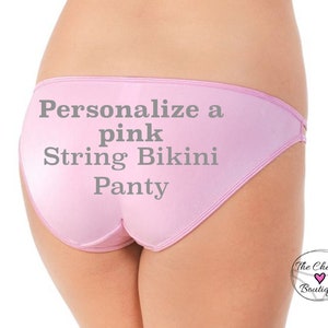 May include: Pink string bikini panty with the text "Personalize a pink String Bikini Panty" printed on the front.