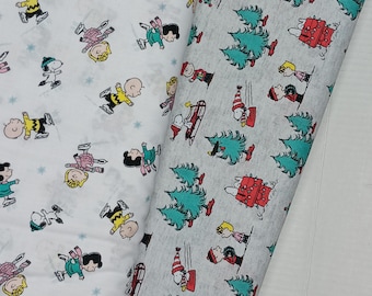 May include: Two pieces of fabric with a white background and a repeating pattern of Peanuts characters ice skating. One fabric has a gray background with a repeating pattern of Peanuts characters decorating a Christmas tree.