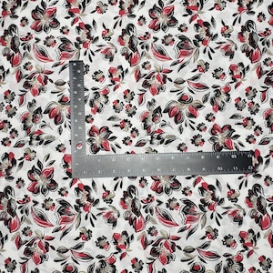 May include: White fabric with a repeating pattern of red, black, and gold floral designs.