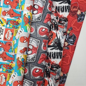 May include: Three different fabric panels featuring a comic book style superhero theme. The panels are red, gray, and white with a black and white panel featuring a superhero in a black and white suit. The panels have the words "POWER", "WITH GREAT POWER", "RESPONSIBILITY", "MAN", "HEAD", and "NUW" printed on them.