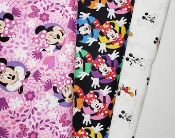 May include: Three different fabric patterns featuring Mickey Mouse and Minnie Mouse. The first pattern is pink with white flowers and butterflies. The second pattern is black with colorful Mickey Mouse and Minnie Mouse images. The third pattern is white with black Mickey Mouse and Minnie Mouse images.