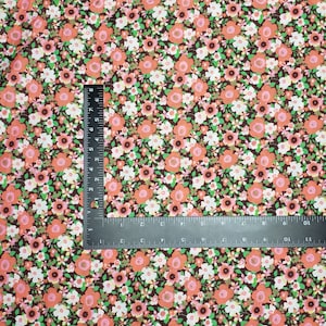 May include: A brown fabric with a repeating pattern of small pink, white, and green flowers.