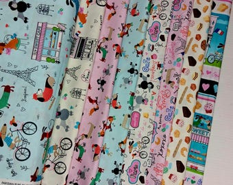 May include: A collection of fabric strips featuring a Parisian theme with illustrations of dogs, bicycles, the Eiffel Tower, cafes, and French pastries. The patterns include text such as Paris, Bonjour, Sweet Cafe, and XOXO in various colors on light backgrounds.