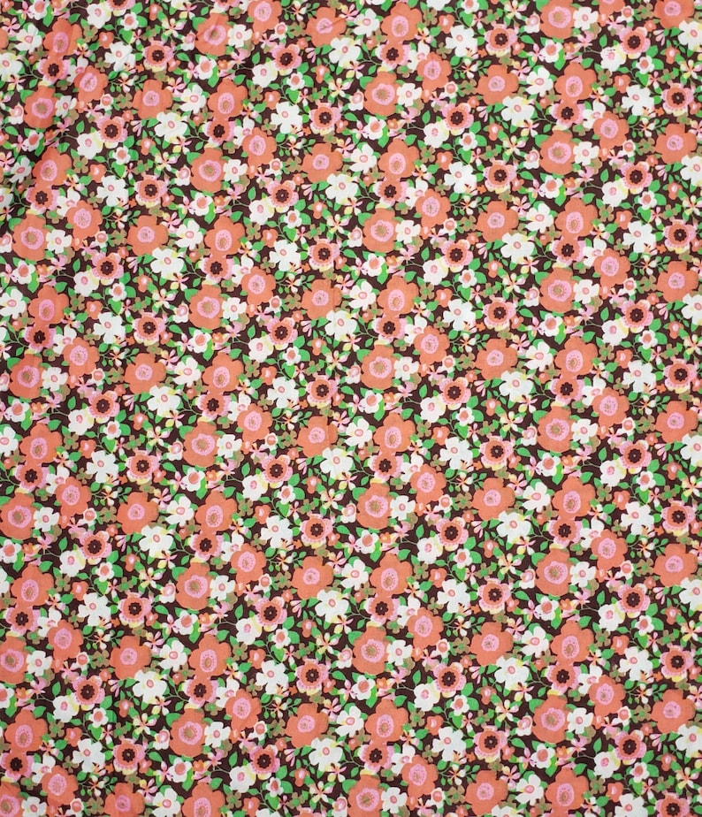 May include: A brown fabric with a repeating pattern of small pink and white flowers. The fabric has a vintage feel.