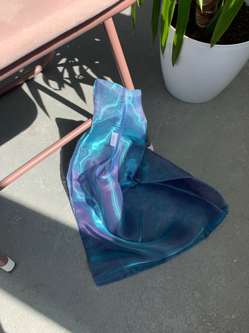 May include: A blue and purple iridescent mesh tote bag with a white tag that says 'LIRA'.