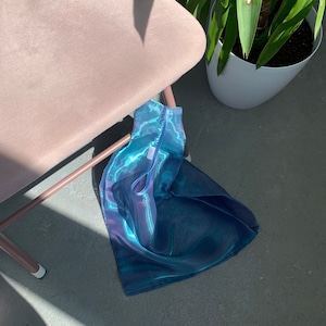 May include: A blue and green iridescent mesh tote bag with a white tag that says 'LILY'.