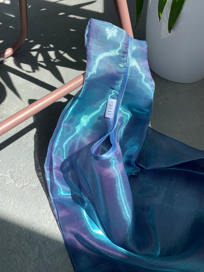 May include: A blue iridescent reusable shopping bag with a white label that says 'IBELLI'.
