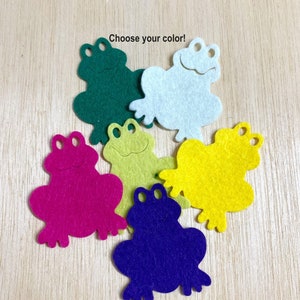 May include: Six felt frog shapes in different colors: green, white, yellow, pink, light green, and purple. The text "Choose your color!" is above the frogs.