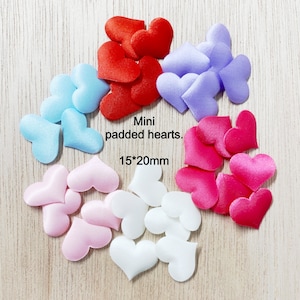 May include: Assortment of mini padded hearts in various colors, including red, pink, white, blue, and purple. The hearts are approximately 15 by 20 millimeters in size.  Mini padded hearts.