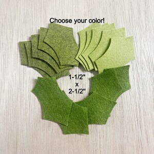 May include: Choose your color! A set of felt fabric squares in shades of green, measuring 1-1/2 inches by 2-1/2 inches.