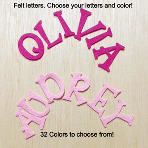 May include: Felt letters in pink and hot pink, spelling out the names "Olivia" and "Audrey". The text "32 Colors to choose from!" is printed below the letters.