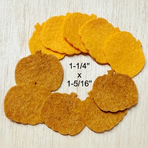 May include: A collection of felt pumpkin shapes in shades of orange and brown. The pumpkins are arranged in a circular pattern. Text on the image reads: 1-1/4" x 1-5/16".