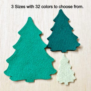 May include: Three felt Christmas tree shapes in different sizes. The largest tree is green, the medium tree is teal, and the smallest tree is light green.