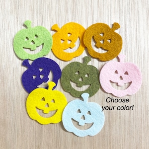 May include: A set of felt pumpkin cutouts in various colors, including green, yellow, orange, purple, brown, pink, and light blue. The pumpkins have a jack-o'-lantern face cut out and the text "Choose your color!" is at the bottom of the image.