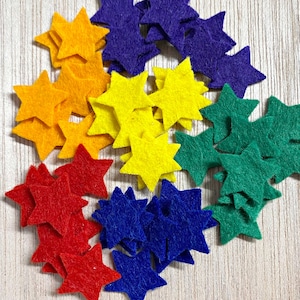 May include: A rainbow assortment of felt stars in various sizes. The stars are arranged in a spiral pattern, starting with purple, then blue, red, yellow, and green.