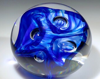 Beautiful ribbons of cobalt blue wrapped around white glass and bubbles in this pretty paperweight