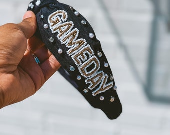 May include: Black headband with the word "GAMEDAY" spelled out in gold and white beads.