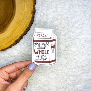 May include: A white milk carton sticker with brown text that reads "MILK you could drink WHOLE if you wanted".