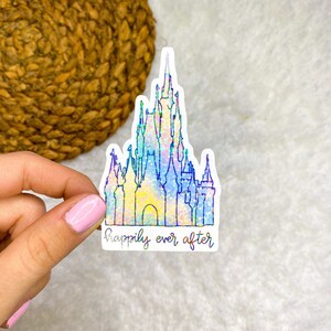 K&ouml;nnte beinhalten: Ein holografischer Aufkleber mit einer detaillierten Umrandung von Cinderellas Schloss und dem Text "happily ever after" darunter.